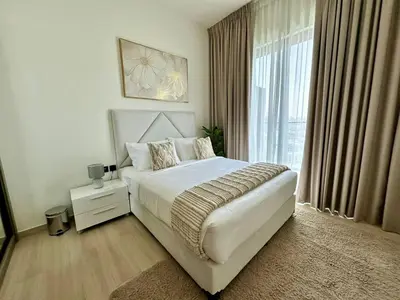 a bedroom with a bed and a large window at Cozy Elegant 1br Balcony, Pool Access, Parking in Dubai