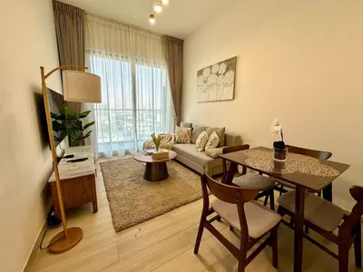 a living room with a table and a couch at Cozy Elegant 1br Balcony, Pool Access, Parking in Dubai