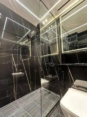 a bathroom with a glass shower with a toilet at Cozy Elegant 1br Balcony, Pool Access, Parking in Dubai