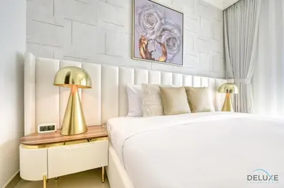 a bedroom with a bed and a table with a lamp at Luxurious 2BR Apartment at Boulevard Point Downtown Dubai by Deluxe Holiday Homes in Dubai