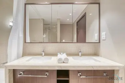 a bathroom with two sinks and a large mirror at Luxurious 2BR Apartment at Boulevard Point Downtown Dubai by Deluxe Holiday Homes in Dubai