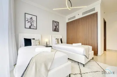 a bedroom with two beds and a sliding door at Luxurious 2BR Apartment at Boulevard Point Downtown Dubai by Deluxe Holiday Homes in Dubai