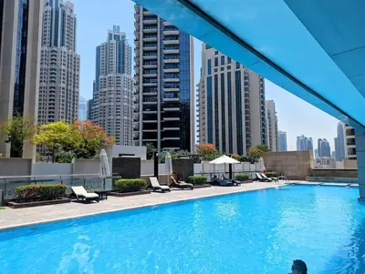 a swimming pool in a city with tall buildings at Downtown Studio near Dubai Mall in Dubai