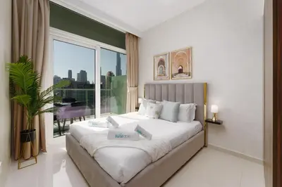 a bedroom with a large bed with a large window at Contemporary Apartment with Burj Khalifa View in Dubai