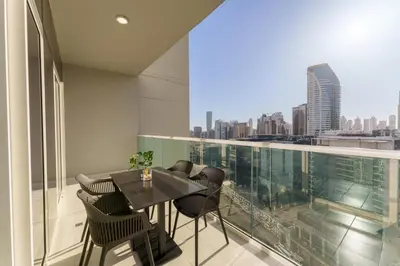 a balcony with a table and chairs and a view of the city at Contemporary Apartment with Burj Khalifa View in Dubai