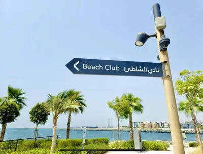 a street sign on a light pole next to a beach at Beach stylish full sea view in Dubai