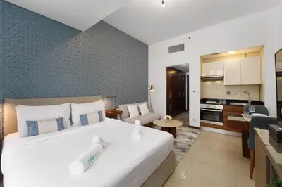a bedroom with a large bed and a living room at Elevated Living studio in Sparkle Tower- Suiteable in Dubai