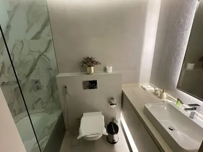a bathroom with a shower and a toilet and a sink at Dubai Marina Walk Gem Modern Apartments with Pool & Gym access, Steps to Beach & Metro Managed by SunnyHomes in Dubai