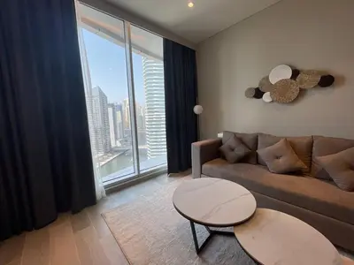 a living room with a couch and a large window at Dubai Marina Walk Gem Modern Apartments with Pool & Gym access, Steps to Beach & Metro Managed by SunnyHomes in Dubai