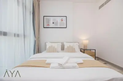a bedroom with a large white bed with a window at Stylish 2BR Apartment at Dubai Hills with Pool Access By ĀYA Boutique in Dubai