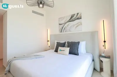 a bedroom with a white bed with a pillow on it at HiGuests - Sky-High Luxury 2BR Apt in Downtown Views Dubai in Dubai