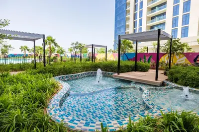 a pool at a resort with a fountain at A Living - Luxury Studio Apartment in Aykon City Canal Views, Business bay in Dubai