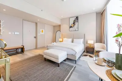 a bedroom with a large white bed and a table at FAM Living - Stunning Modern Marina Apartment in Dubai