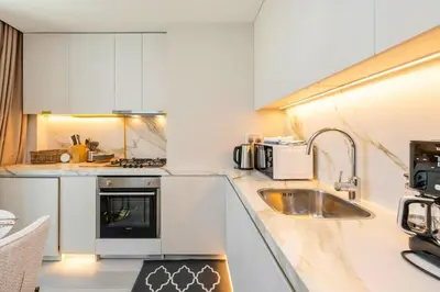 a kitchen with white cabinets and a sink at FAM Living - Stunning Modern Marina Apartment in Dubai
