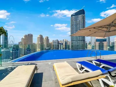 a swimming pool with two lounge chairs and an umbrella at FAM Living - Stunning Modern Marina Apartment in Dubai