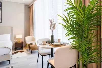 a living room with a table and a plant at FAM Living - Stunning Modern Marina Apartment in Dubai