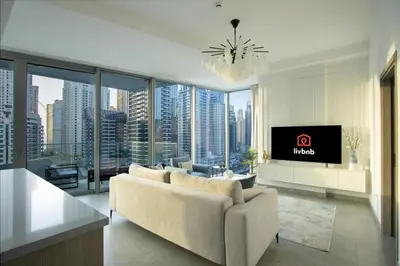 a living room with a couch and a tv at Deluxe 1BR Corner Suite with Marina Views in Dubai