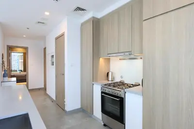 a kitchen with a stove and a counter top at Deluxe 1BR Corner Suite with Marina Views in Dubai