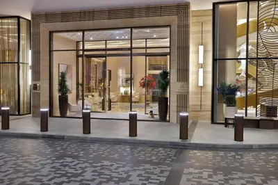a lobby of a building with glass doors and potted plants at Palm Tower Luxury 1BR Sea View Suites with 5 Star Hotel Amenities in Dubai
