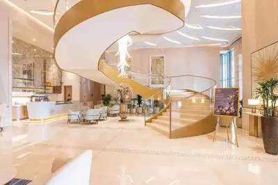 a lobby with a spiral staircase in a building at Palm Tower Luxury 1BR Sea View Suites with 5 Star Hotel Amenities in Dubai
