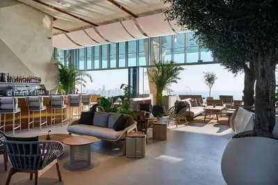 a living room with chairs and tables and windows at Palm Tower Luxury 1BR Sea View Suites with 5 Star Hotel Amenities in Dubai