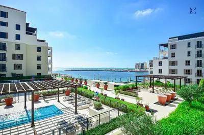 a view of a building with a pool and buildings at Luxury Escapes - Sea View 1Bed Apartment in Port de Lamer in Dubai
