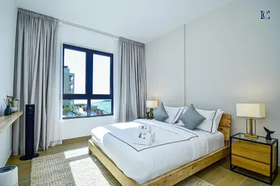 a white bedroom with a large bed and a window at Luxury Escapes - Sea View 1Bed Apartment in Port de Lamer in Dubai