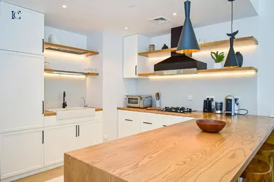 a kitchen with white cabinets and a wooden counter top at Luxury Escapes - Sea View 1Bed Apartment in Port de Lamer in Dubai
