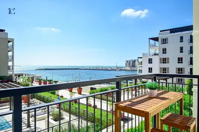 a balcony with a table and a view of the beach at Luxury Escapes - Sea View 1Bed Apartment in Port de Lamer in Dubai