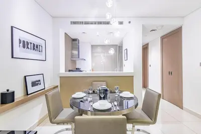 a dining room with a glass table and chairs at Dubai Dreaming Stylish 1BR, DAMAC Towers Paramount in Dubai