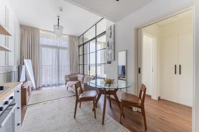 a kitchen and dining room with a glass table and chairs at HAVN - 1 Bedroom in Collective, Dubai Hills Estate in Dubai