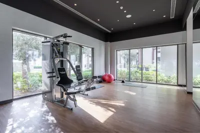 a gym with treadmills and ellipticals in a room with windows at HAVN - 1 Bedroom in Bayshore 2, Creek Beach in Dubai