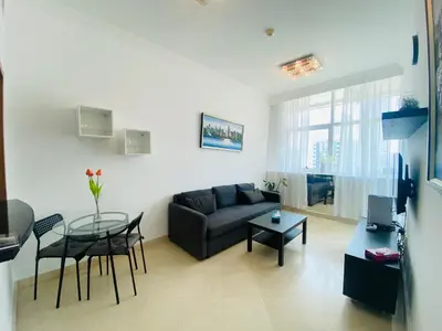 a living room with a couch and a glass table at JBR Walk Full Apartment Marina View in Dubai