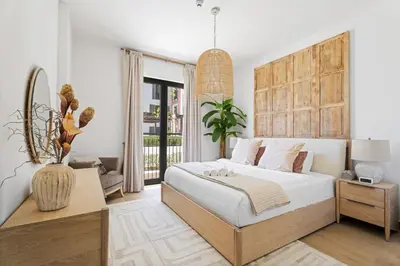 a bedroom with a large bed with a wooden headboard at Ocean View 2BR with a Pool & Gym, 2 min to Beach in Dubai