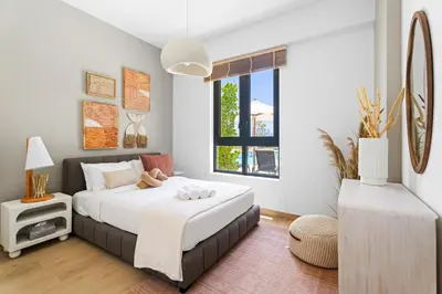 a bedroom with a bed and a window at Ocean View 2BR with a Pool & Gym, 2 min to Beach in Dubai