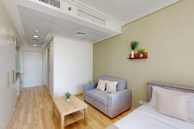 a room with a bed and a couch and a table at Goldcrest Views 2 - Elegant Studio in Dubai