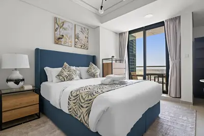 a bedroom with a large bed and a balcony at Stonetree - GoldCrest Views 2 - Peaceful Community in Dubai