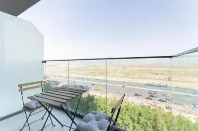 a balcony with a bench and a view of a highway at HAVN - Studio Apartment in Bloom Towers, JVC in Dubai