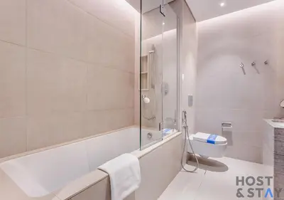 a bathroom with a shower and a tub and a toilet at Highfloor 2-BR in Address Jumeirah Beach Residence in Dubai