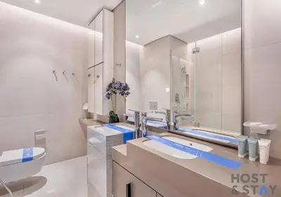 a bathroom with a sink and a toilet and a mirror at Highfloor 2-BR in Address Jumeirah Beach Residence in Dubai