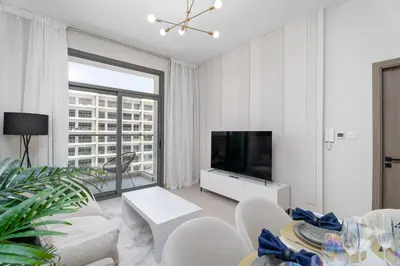 a white living room with a tv and a large window at Nasma Luxury Stays - Laya Heights in Dubai