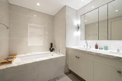 a bathroom with a tub and two sinks and a mirror at Stunning Burj & Fountain Views Luxury 2 BR in Dubai