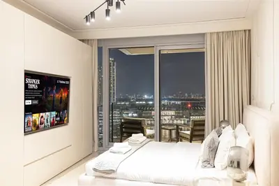 a bedroom with a bed and a large window at Stunning Burj & Fountain Views Luxury 2 BR in Dubai