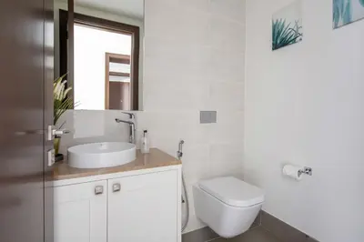a bathroom with a sink and a toilet and a mirror at Frank Porter - Opera Grand in Dubai