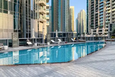 a large swimming pool in a city with tall buildings at Frank Porter - Opera Grand in Dubai