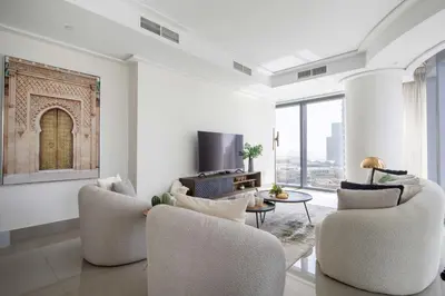 a living room with two chairs and a tv at Frank Porter - Opera Grand in Dubai
