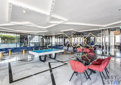 a lobby with a ping pong table and chairs at Upgraded Studio in Business Bay in Dubai