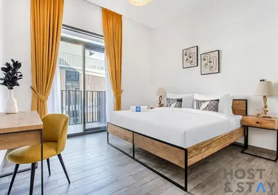 a bedroom with a bed and a desk and a chair at 1BR Belgravia Apartment with pool view in Dubai