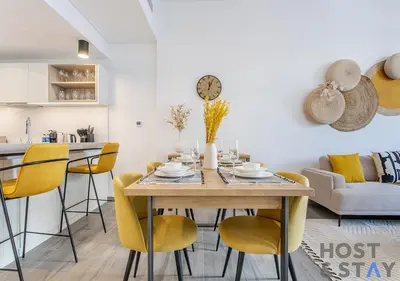 a kitchen and dining room with a table and chairs at 1BR Belgravia Apartment with pool view in Dubai