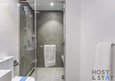 a shower with a glass door in a bathroom at 1BR Belgravia Apartment with pool view in Dubai